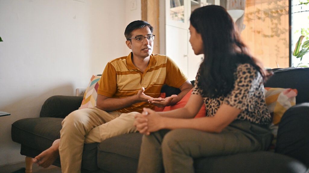 Couple sitting on sofa having serious discussion