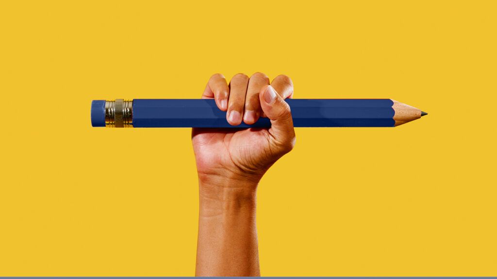 Hand holding a large pencil