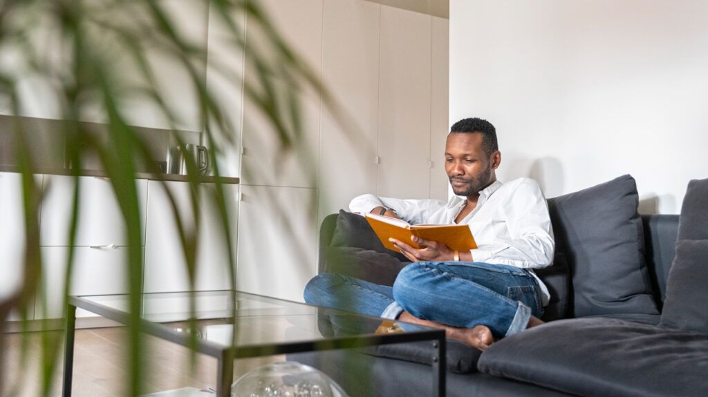 Person reading a book on a couch