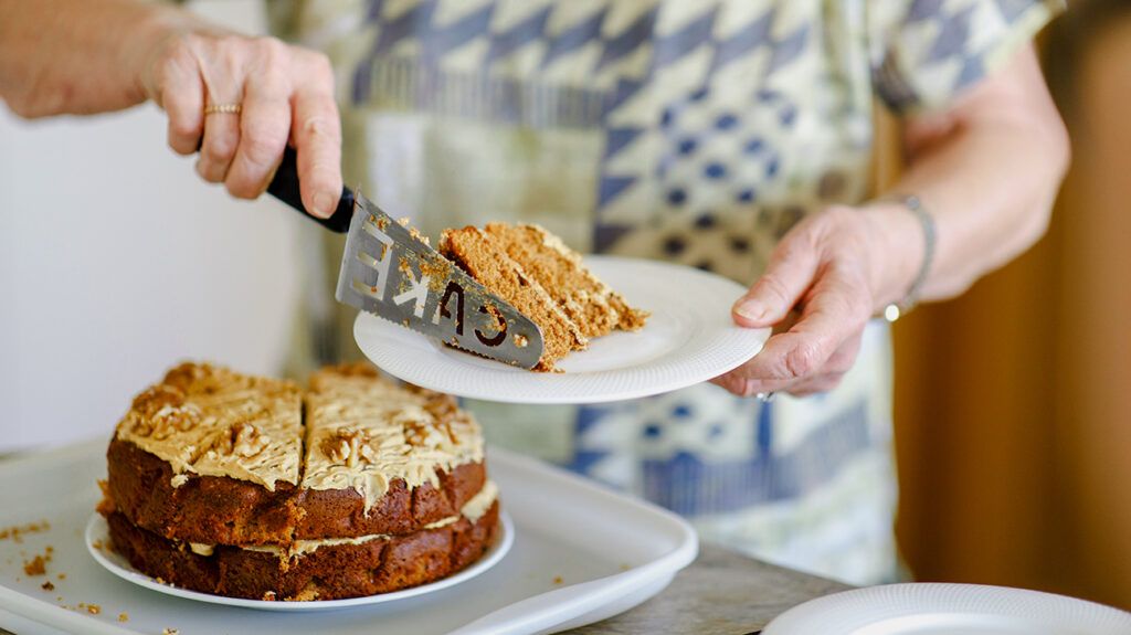 Person grabbing a slice of cake in their breakroom, eating when not hungry