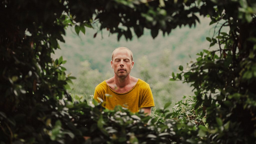 Man focusing on his breath in a moment of anxiety while out on a hike