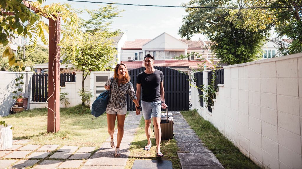 Young couple holding hands coming home from vacation