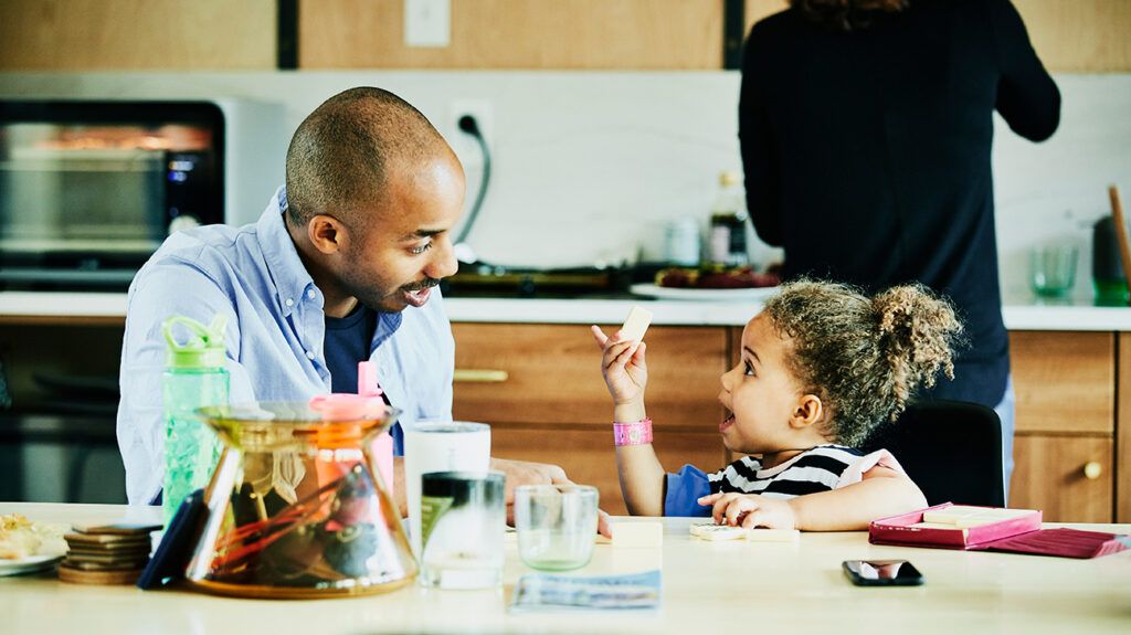 Father and daughter playing at kitchen table