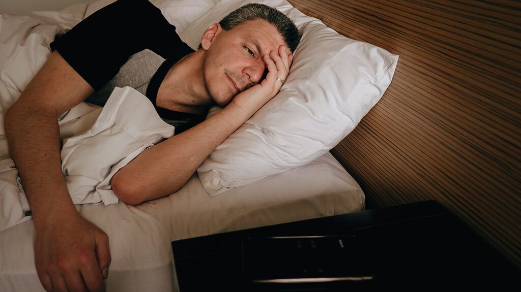 Man lying awake in bed after a nightmare