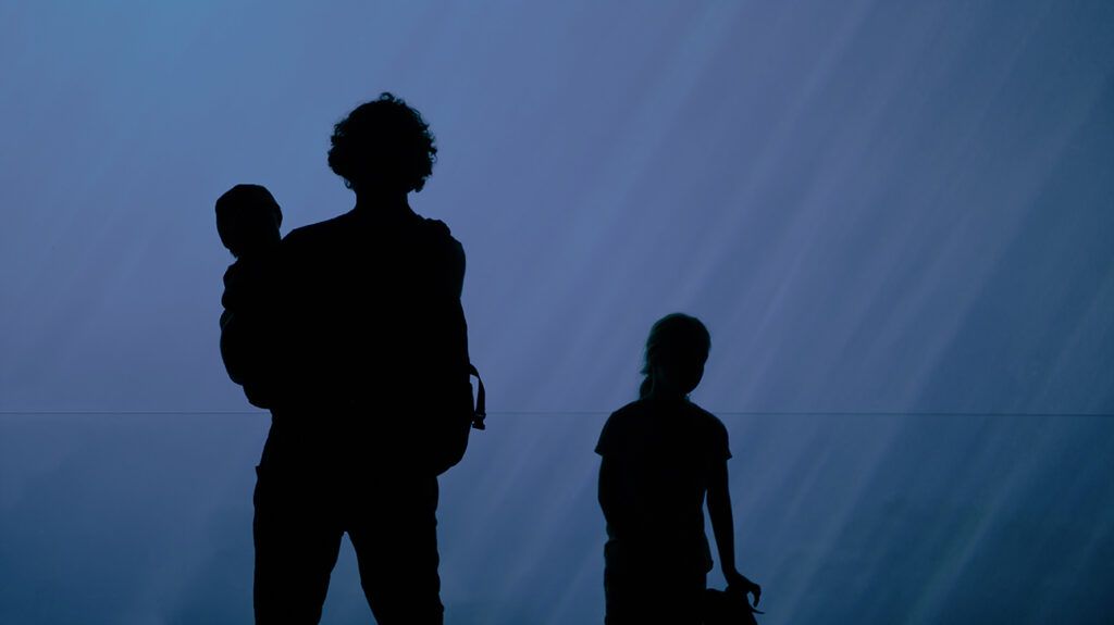 Silhouette of father with children at aquarium