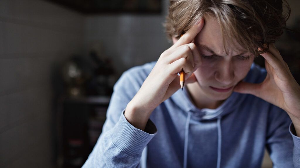 Teenage boy is trying to study with developing symptoms of schizophrenia