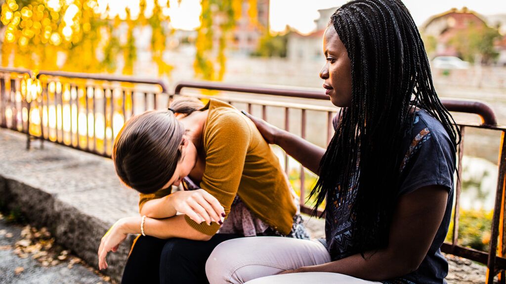 Woman comforting a friend with suicidal ideation