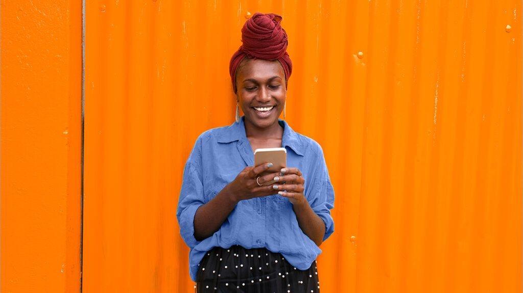 woman with head wrap looking at smartphone