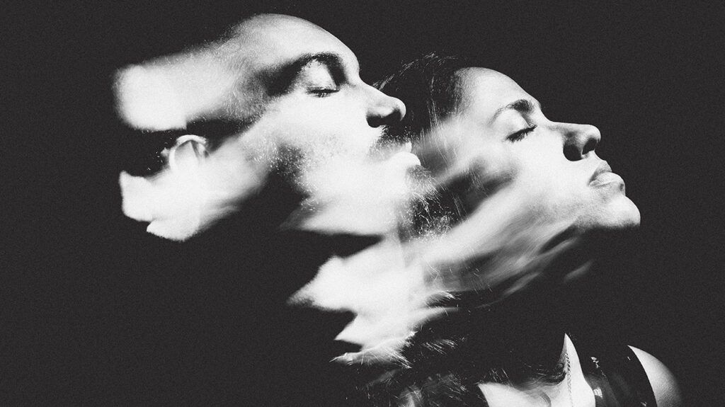Black and white long-exposure portrait of a man and a woman giving the image a distorted feel