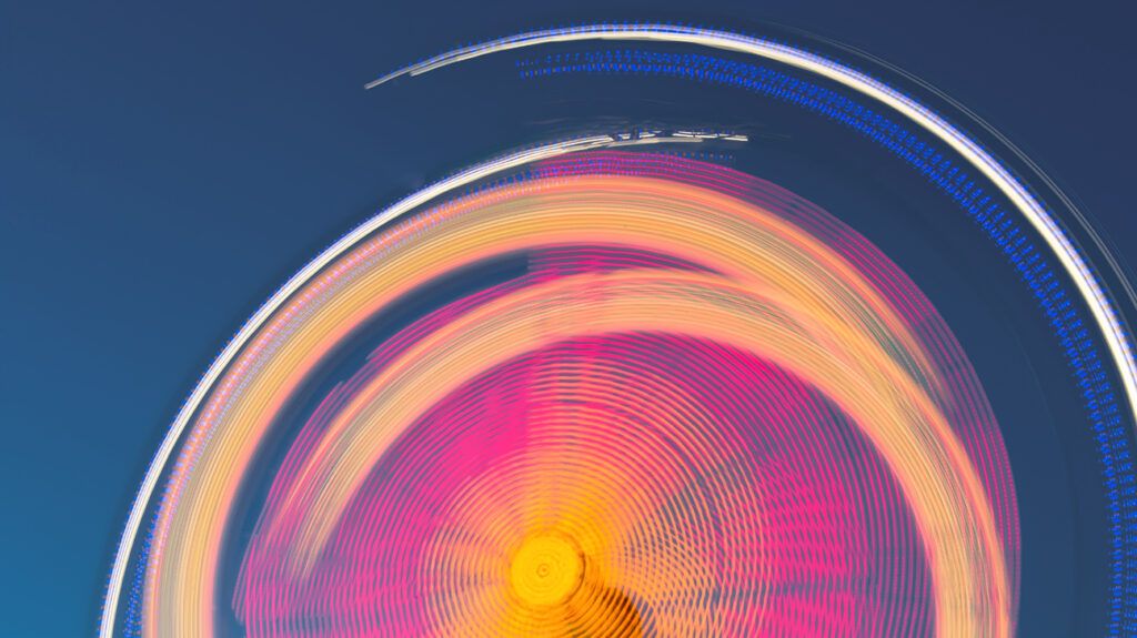 Blurred motion Ferris wheel lights at night