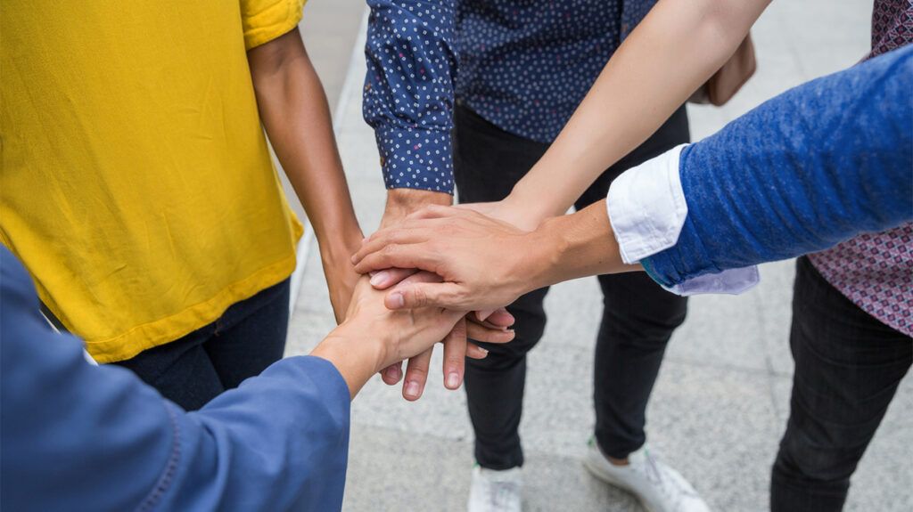 Hands joined in the middle of a group