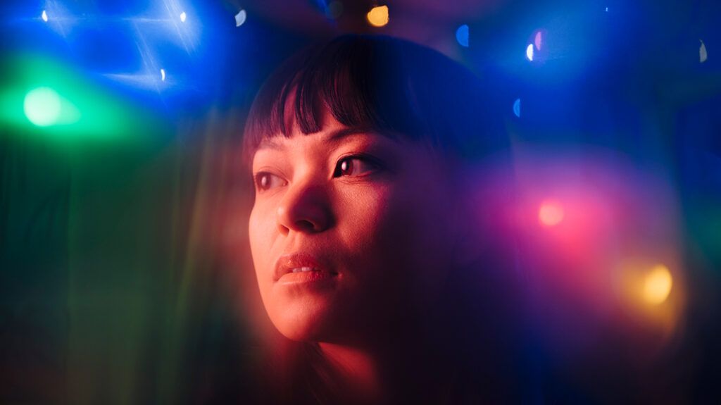 Close-up of woman in multicolored lights