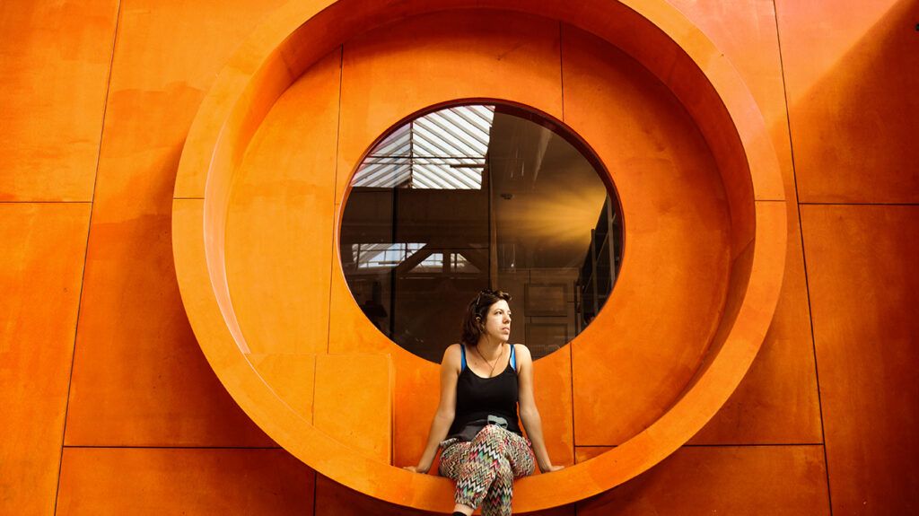 Woman sitting in a large circular seat, thinking about her period and her depression symptoms
