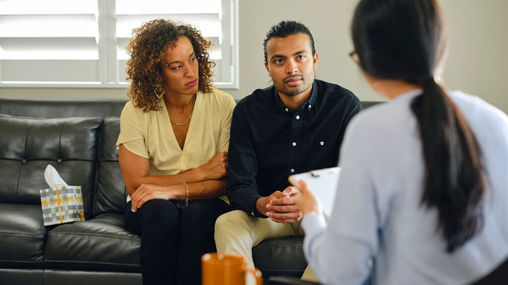 A couple sitting with a counselor, trying to maximize couples therapy