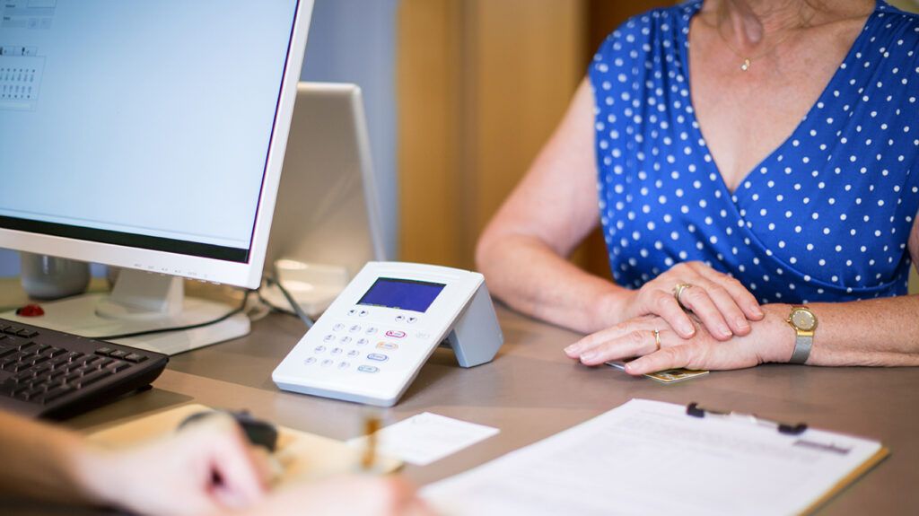 Cropped image of senior woman at reception desk