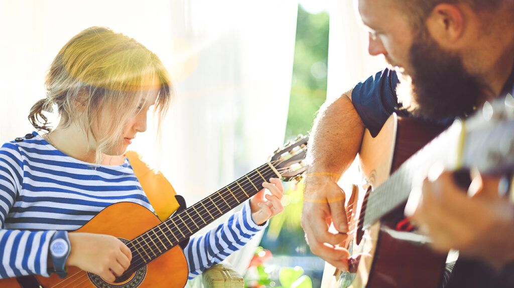 Autistic girl receiving music therapy guitar session