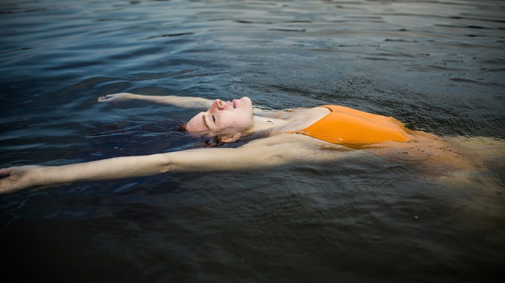 Young woman floating in a lake