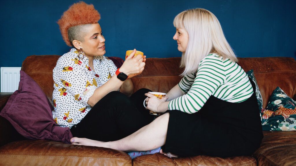 Couple sitting on couch drinking coffee