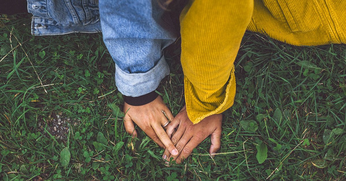 https://media.post.rvohealth.io/wp-content/uploads/sites/4/2022/01/couple-holding-hands-sitting-grass-1200x628-facebook-1200x628.jpg