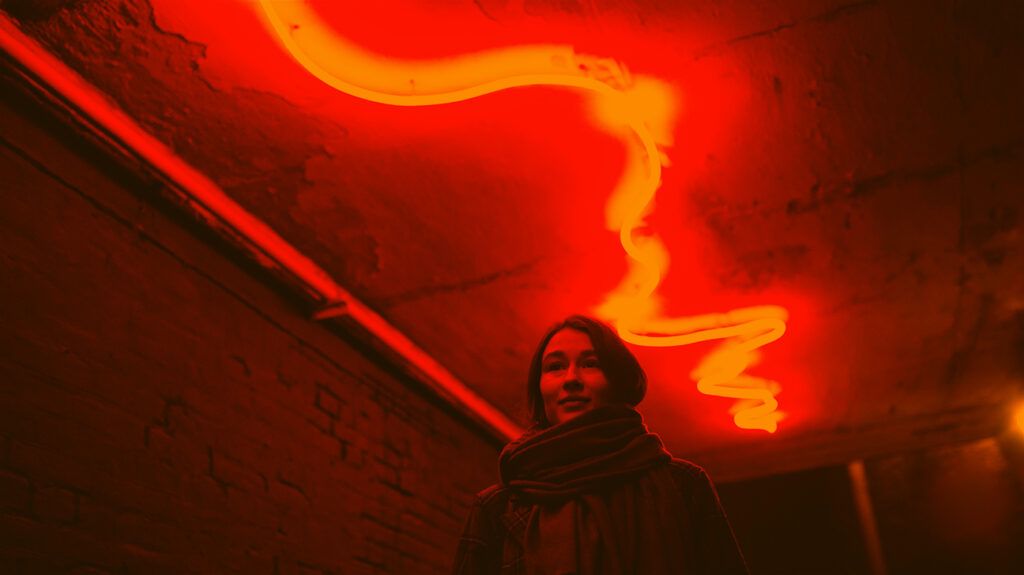 Portrait of woman in dark with neon red light 