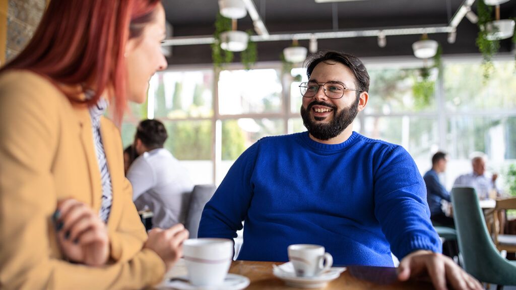 Man sitting with a date for coffee, managing his anxiety
