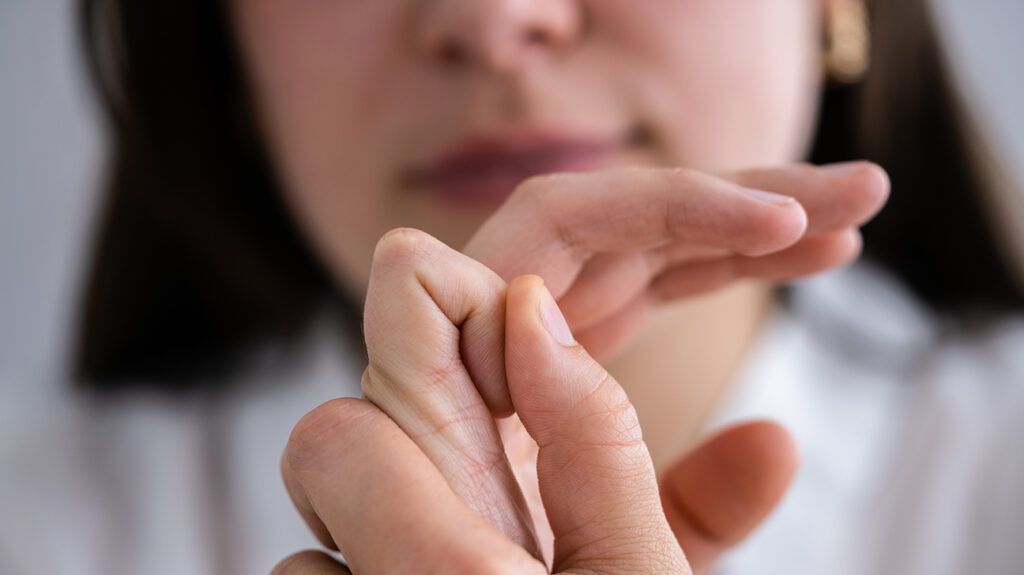 Person with adhd humming and cracking her knuckles as stims to soothe and focus