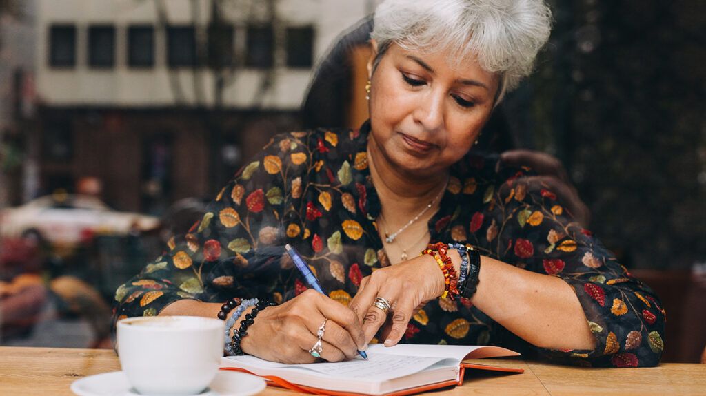 Woman journaling in coffee shop