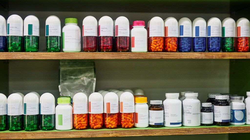Variety of supplements in different colors and sizes on two shelves in a store