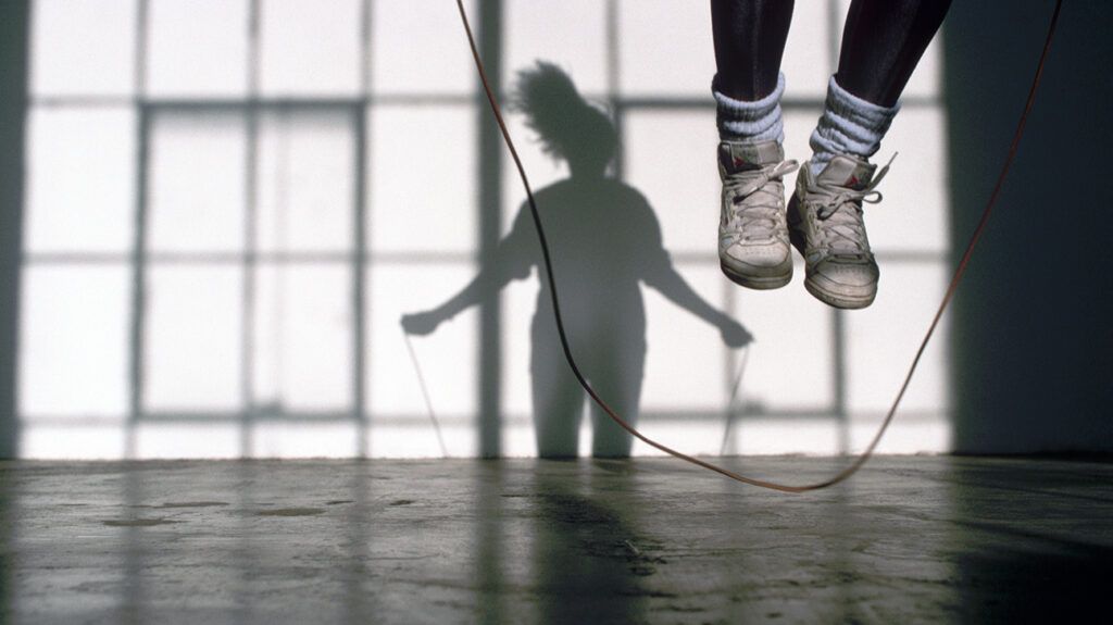 Feet of person exercising by jumping rope