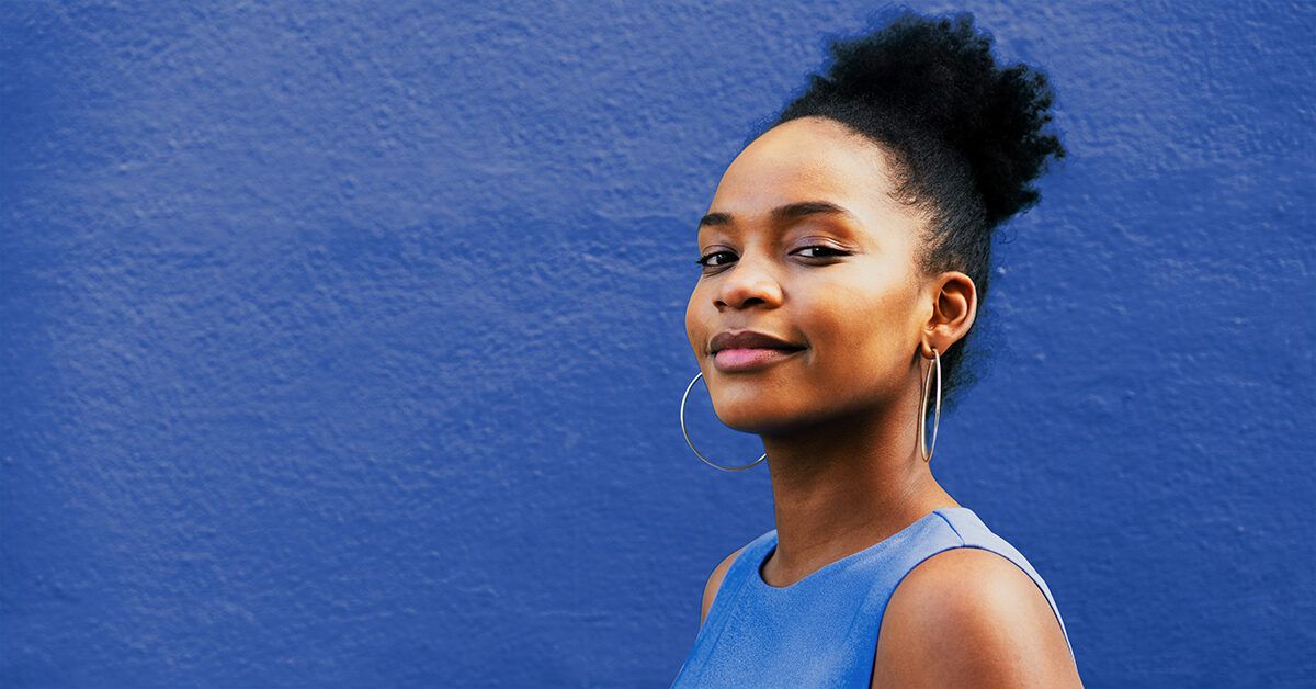 https://media.post.rvohealth.io/wp-content/uploads/sites/4/2022/02/woman-portrait-smiling-looking-at-camera-blue-wall-1200x628-facebook-1200x628.jpg