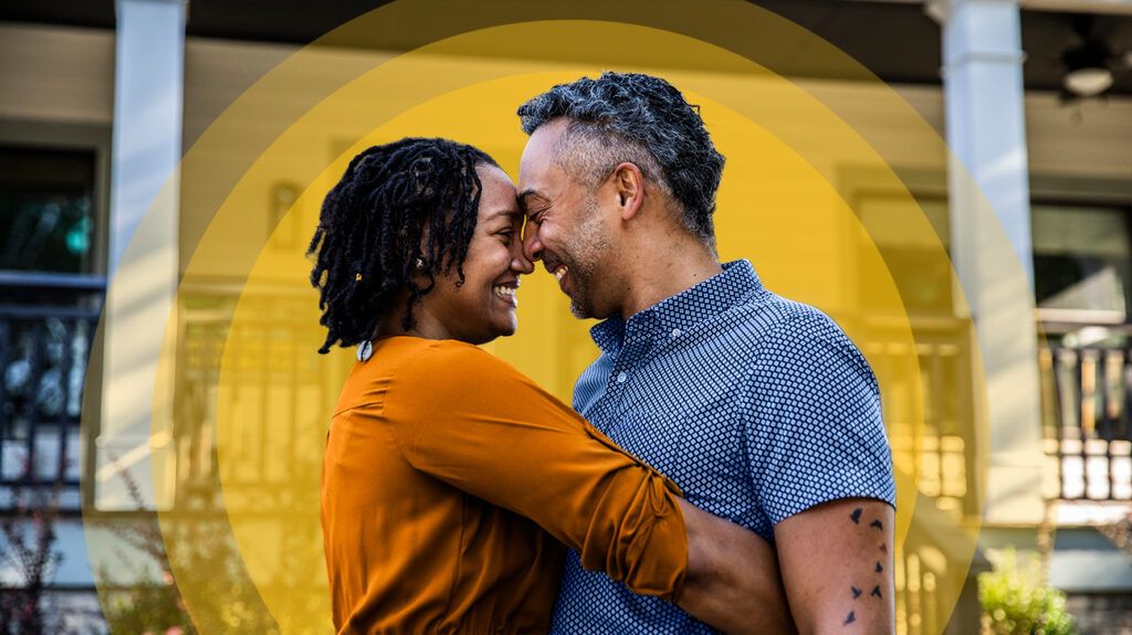 Couple embracing in front of home