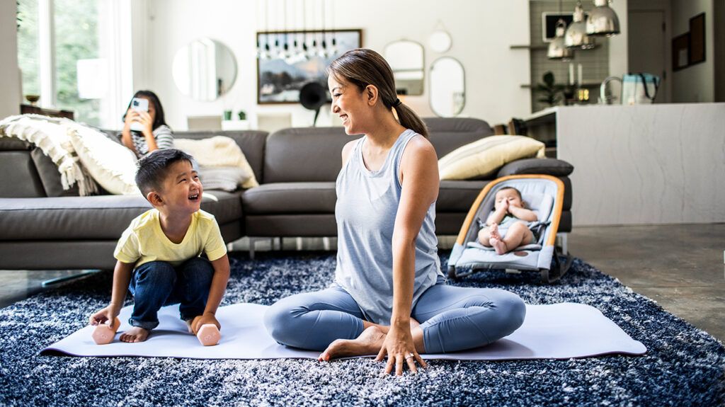 Mother doing yoga with children at home