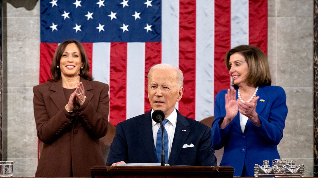 President Joe Biden stands in front of Nancy Pelosi and Kamala Harris during his State of the Union address.