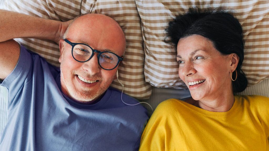 Couple laying in bed smiling