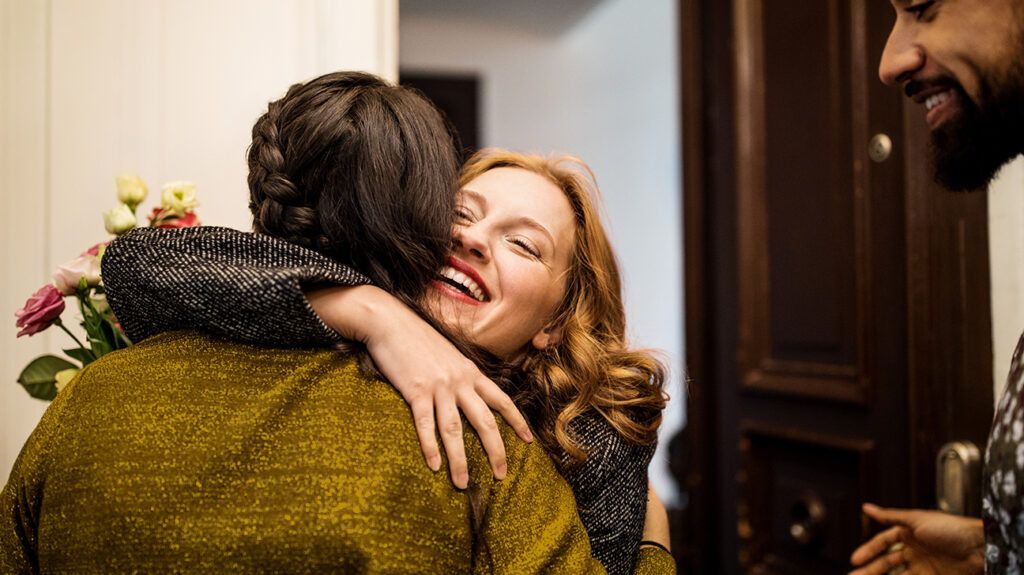Woman embracing and hugging a friend at a dinner party