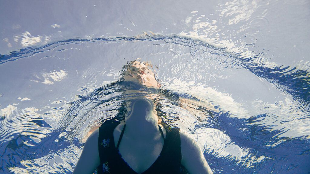 Woman swimming; viewed from below