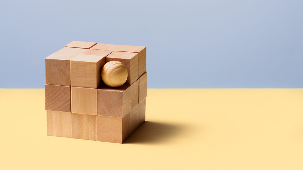 A wooden cube puzzle but one corner piece is replaced by a wooden ball