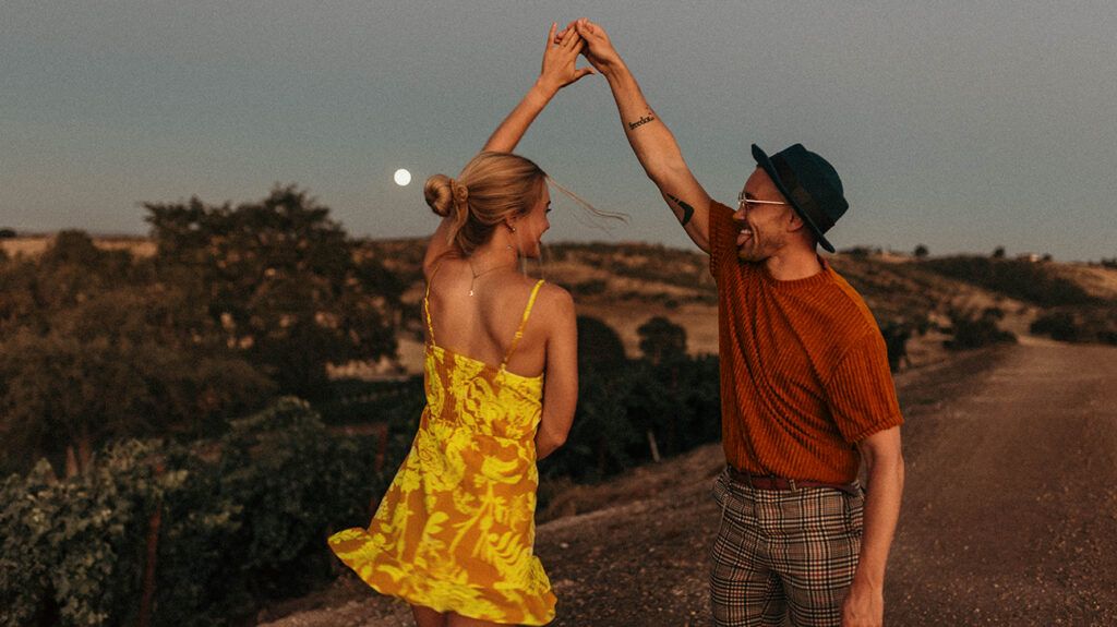 A couple dancing in the moonlight , enjoying an exclusive relationship