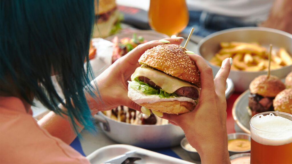 Woman about to take a bite of a burger