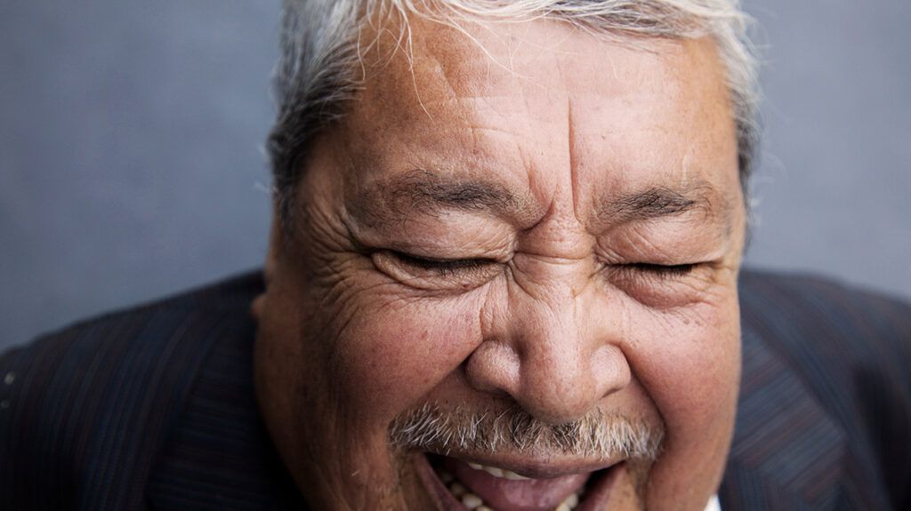 Man dressed for a somber occassion, experiencing paradoxical laughter