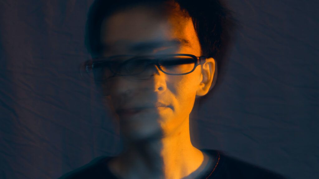 Man with glasses,half his face blurred and distorted