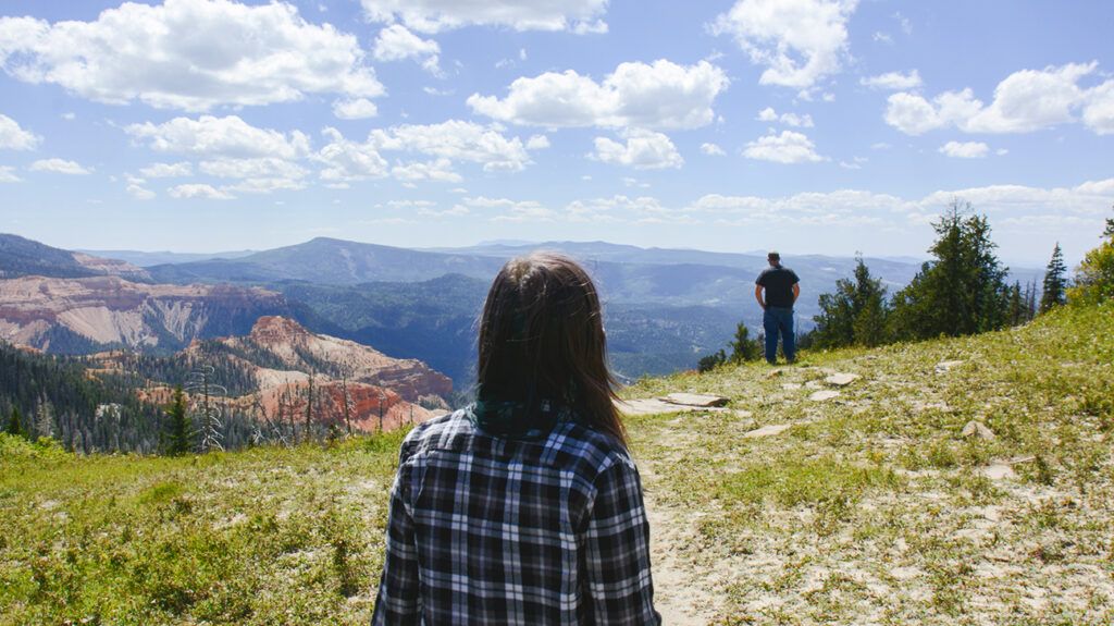 Daughter outside, gazing at her father who has schizophrenia, from afar