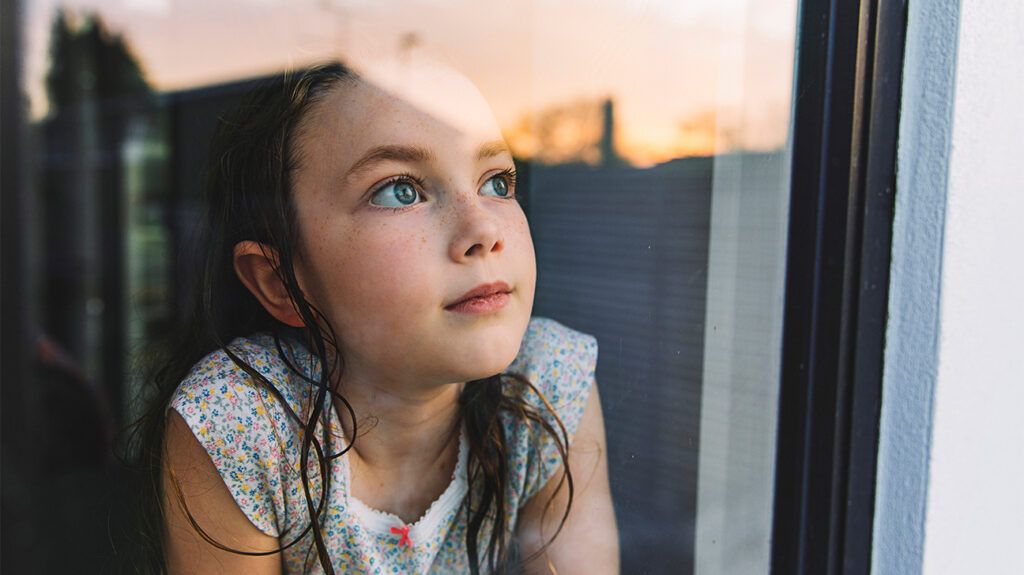 Young girl looking out the window