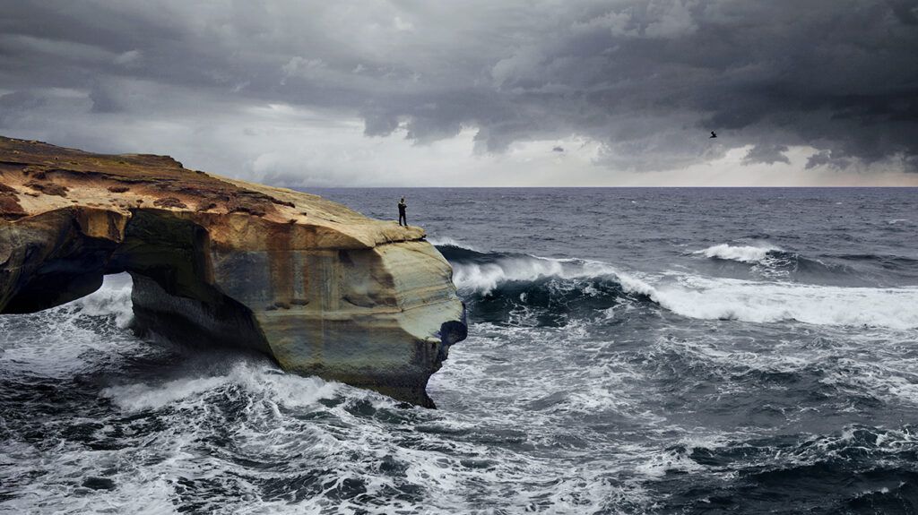 Person with bipolar disorder standing on a solid rock in a storm, symbolic of a spiritual anchor