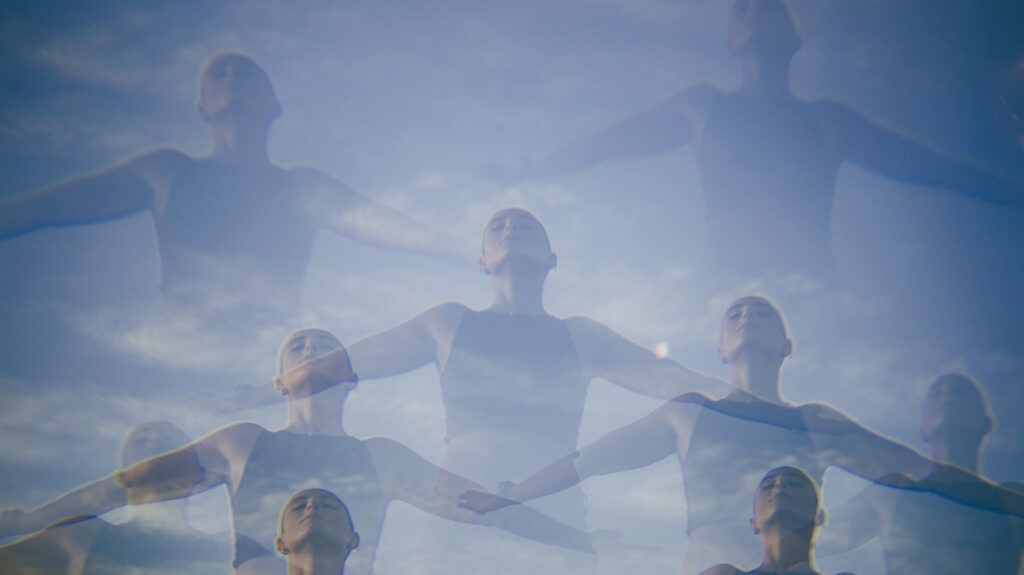 A multiple exposure photo of a woman with open arms