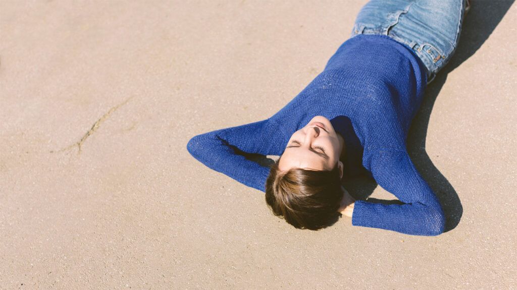 Woman laying in the sun with eyes closed