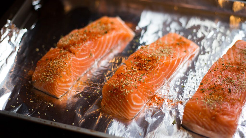 seasoned salmon in the oven on aluminum foil 