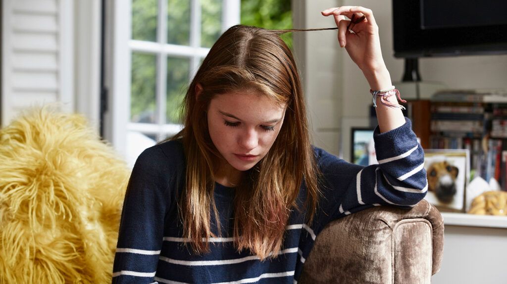 girl with anxiety twirling her hair as part of stimming behavior