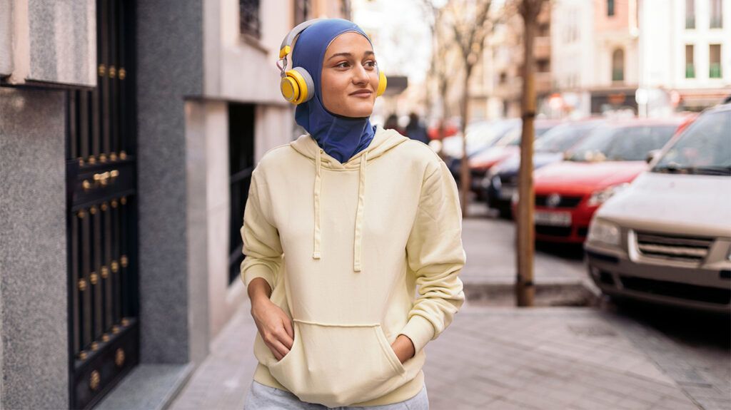 Young woman walking with headphones on