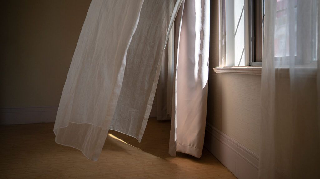 Curtains being blown from open window, symbolic of clearing the air.